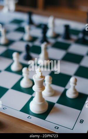 Pezzo di scacchi del re sulla scacchiera con pezzo di scacchi sfocato sfondo Foto Stock
