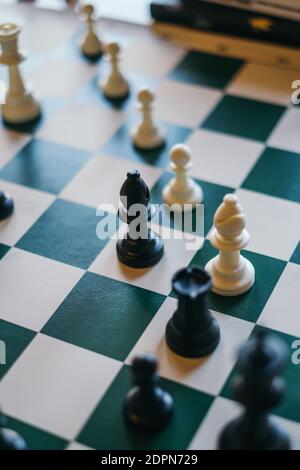 Pezzi di scacchi sulla scacchiera con sfondo chiaro sfocato Foto Stock