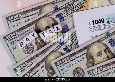 Modulo di dichiarazione fiscale IRS 1040 con banconote in dollari USA da vicino Foto Stock