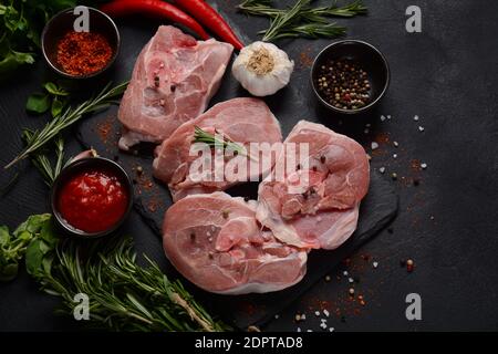 Crudi la carne di ossobuco fresco su un tavolo con spezie ed erbe. Ingredienti per stufato italiano Foto Stock