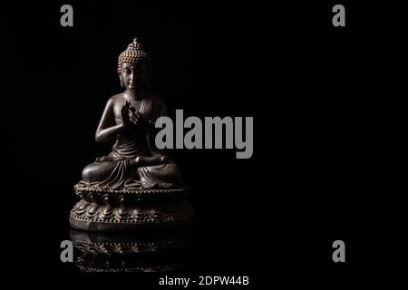 Statua di Buddha seduta in meditazione con spazio copia nero . Zen e meditazione concetto. Foto Stock