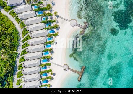 Paesaggio tropicale con palme, ombrelloni, sabbia bianca, acqua blu, onde. Vista dall'alto, piscina, piscina, splendida spiaggia, spiaggia costiera, aereo superiore Foto Stock