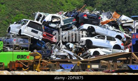 Automobili distrutte accatastate al cantiere di riciclaggio del metallo Foto Stock