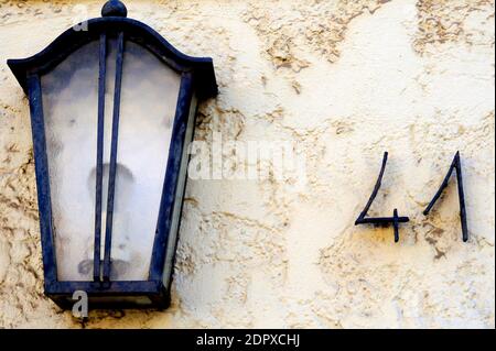 Una parete bianca, una lanterna blu e casa numero 41 Foto Stock