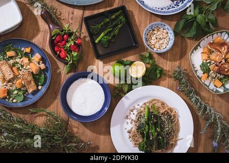 Verdure alla griglia e piatti salutari su un elegante tavolo di legno. Piatti mediterranei con asparagi, tofu, seitan e Halloumi. Glutine Foto Stock