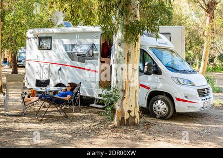 Donna comodamente sdraiata al telefono davanti a una casa mobile, campeggio, Bari Sardo, Provincia di Nuoro. Sardegna (Italia) Foto Stock