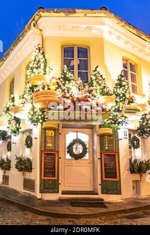 Belle decorazioni natalizie a Vilnius, Lituania, con alberi di Natale e macaroni giganti, luci e sfondo notturno, verticale Foto Stock