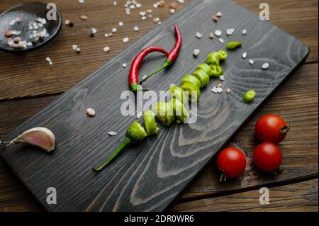 Pepe fresco tagliato a bordo, fondo di legno Foto Stock