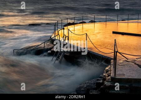 Bronte Rock Pool di Sydney con riflessi dorati all'alba. Foto Stock