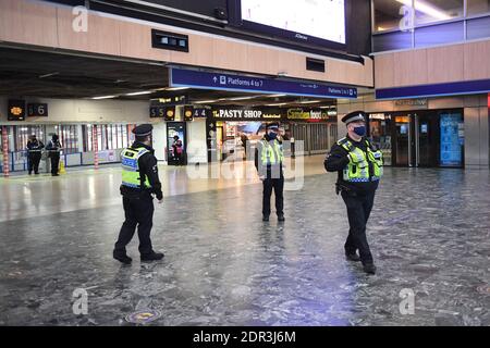 Funzionari di polizia alla stazione di Euston, Londra, con un maggior numero di dipendenti impiegati per far rispettare le regole di viaggio alle stazioni di Londra, E l'opinione pubblica viene esortata ad aderire agli orientamenti del governo dopo che il primo ministro Boris Johnson ha annunciato sabato che dalle aree domenicali del Sud-est attualmente al livello 3 sarà trasferito in un nuovo livello 4 per due settimane Ð ritornando effettivamente alle regole di blocco di novembre, dopo che gli scienziati hanno avvertito della diffusione rapida del coronavirus della nuova variante. Foto Stock