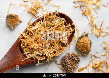 Fiore di Calendula essiccato su un cucchiaio di legno Foto Stock