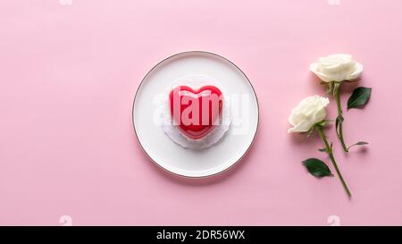 composizione piatta con torta cuore rossa e bianco delicato fiori Foto Stock