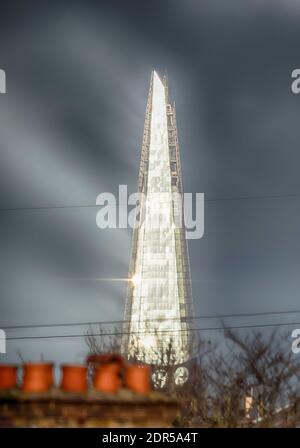 Wimbledon, Londra, Regno Unito. 20 dicembre 2020. La bassa luce solare invernale colpisce lo Shard, l'edificio più alto del Regno Unito, e si vede riflettere verso l'alto da ovest verso il lato di vetro contro uno sfondo di nuvole grigie. Credit: Malcolm Park/Alamy Live News. Foto Stock