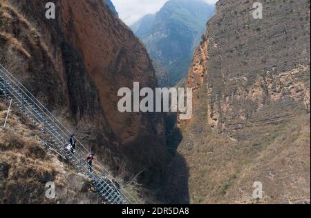 (201220) -- PECHINO, 20 dicembre 2020 (Xinhua) -- Foto aerea scattata il 13 maggio 2020 mostra MOU'se Laruo e sua moglie Jike Aniu con i loro due bambini che scendono la scala di acciaio per lasciare il villaggio di Atulieer e spostarsi nella loro nuova casa nella contea di Zhaojue, provincia di Sichuan, nella Cina sud-occidentale. Complessivamente 31 famiglie nel villaggio di Atulieer che vivono sotto la soglia di povertà si sono spostate nelle loro nuove case in una comunità di recente costruzione per alleviare la povertà delocalizzazione nella contea di Zhaojue. La Cina ha realizzato grandi risultati in termini di riduzione della povertà che hanno impressionato il mondo, con quasi 100 milioni di persone che sono uscite dalla povertà. (Xinhu Foto Stock