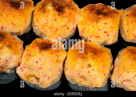 Set di panini al sushi al forno isolati su sfondo nero. Rotolo di sushi al forno isolato. Cibo tradizionale giapponese con pezzi di sushi deliziosi maki Foto Stock