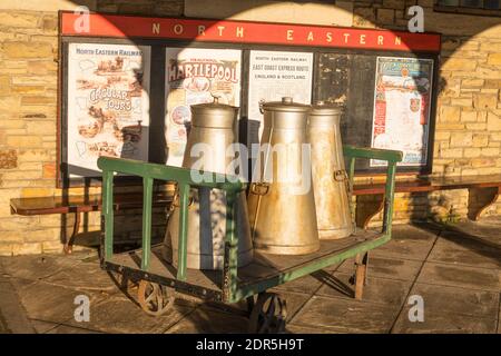 Il latte vecchio si inzidisce su un deposito bagagli la piattaforma della stazione ferroviaria a Beamish Museum, Co. Durham, Inghilterra, UK Foto Stock