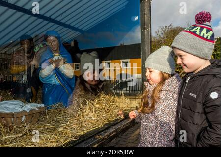 Bantry, West Cork, Irlanda. 20 dicembre 2020. Il mercato di Natale di Bantry ha avuto luogo oggi con molti locali frequentanti. C'erano stalle che vendono artigianato, musica dal vivo e Babbo Natale ha fatto un'apparizione. Prendendosi un momento per guardare la scena della Presepe di Bantry erano Lillie e Fionn Minihane da Bantry. Credit: AG News/Alamy Live News Foto Stock