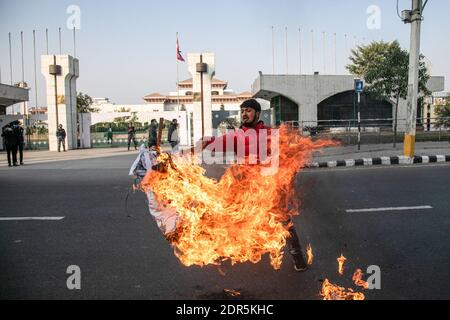 Kathmandu, Nepal. 20 dicembre 2020. Un manifestante che brucia un effigie del primo ministro Khadga Prasad oli, Di fronte all'edificio del parlamento durante la manifestazione.il presidente del Nepal ha sciolto il Parlamento domenica dopo che il primo ministro ha raccomandato il movimento in mezzo ad un feud crescente all'interno del suo partito comunista che è probabile spingere la nazione Himalayana in una crisi politica. Le elezioni parlamentari si terranno il 30 aprile e il 10 maggio, secondo una dichiarazione dell'ufficio del Presidente Bidya Devi Bhandari. Credit: SOPA Images Limited/Alamy Live News Foto Stock