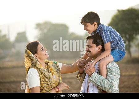 Felice famiglia rurale indiana su campo agricolo Foto Stock