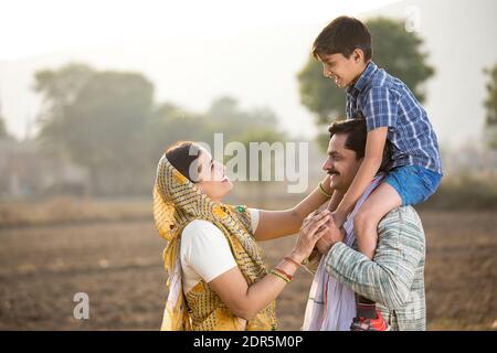 Felice famiglia rurale indiana su campo agricolo Foto Stock