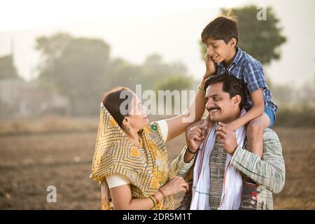 Felice famiglia rurale indiana su campo agricolo Foto Stock