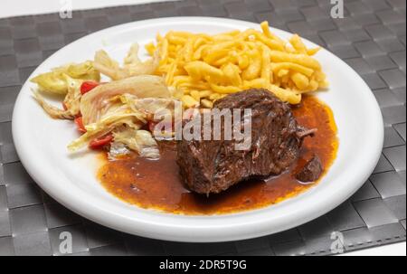 Guance di bue con tagliatelle e insalata Foto Stock