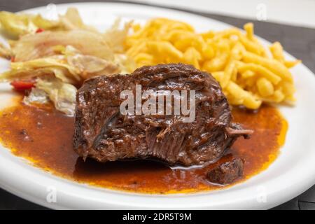 Guance di bue con tagliatelle e insalata Foto Stock