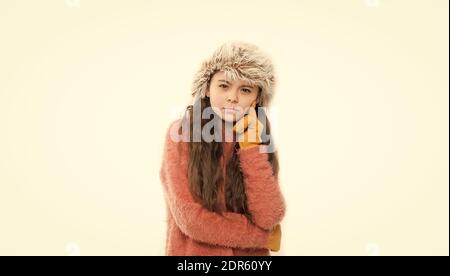 Anti statica prodotto per i capelli. Statico e l'effetto crespo. Bambino adorabile lunghi capelli morbidi cappello di pelliccia. Prodotti per la cura del bambino concetto. Ragazza capelli lunghi indossare pellicce hat sfondo bianco. Inverno shampoo e balsamo prevenire danni ai capelli. Foto Stock