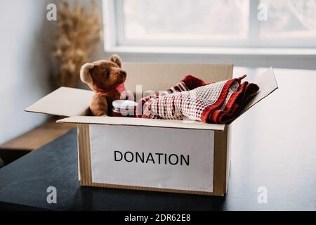 Scatola di donazione, Camatori di regali di beneficenza, aiutare i rifugiati e i senzatetto. Natale Natale beneficenza confezione con abiti caldi, cibo e giocattoli a casa Foto Stock