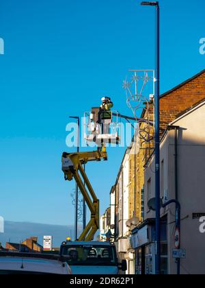 Uomo su un paranco idraulico che esegue una riparazione a. Una telecamera TVCC Foto Stock