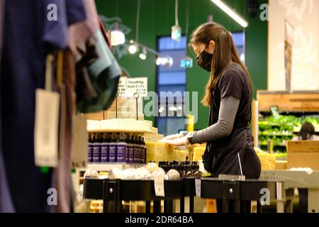 Assistente del negozio mascherato che ha impostato un'esposizione di sapone al mercato locale Whole Foods a Lansdowne, Ottawa, Ontario, Canada. Foto Stock