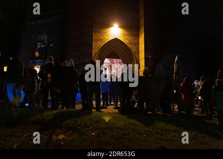 Cradley, West Midlands, Regno Unito. 20 dicembre 2020. I fedeli si riuniscono fuori dalla chiesa di San Pietro a Cradley, West Midlands, per un servizio di carol all'aperto in una fredda serata. Credit: Peter Lopeman/Alamy Live News Foto Stock