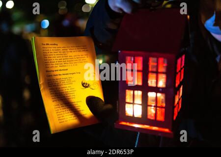 Cradley, West Midlands, Regno Unito. 20 dicembre 2020. Un foglio di carol è illuminato da una lanterna mentre i fedeli si riuniscono fuori della chiesa di San Pietro a Cradley, West Midlands, per un servizio di carol all'aperto in una serata fredda. Credit: Peter Lopeman/Alamy Live News Foto Stock