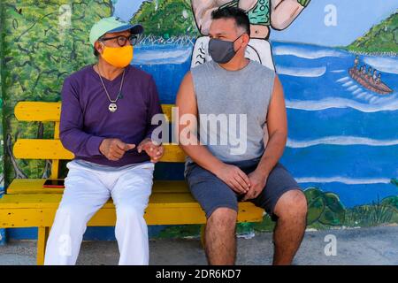 Uomini che discutono durante la pandemia di Covid-19 nella piccola città di Sisal, Yucatan, Messico Foto Stock