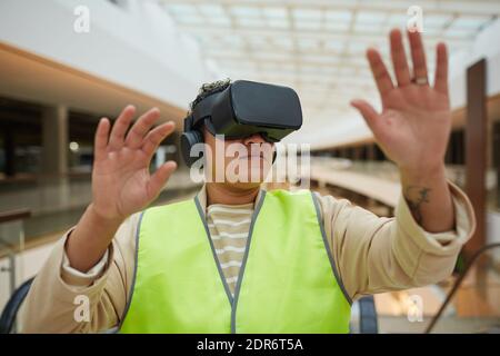 Ritratto di un ingegnere femminile che indossa un visore VR mentre visualizza l'architettura progetto di progettazione Foto Stock