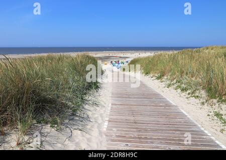 Un sentiero in legno conduce alla spiaggia di sabbia Sul Mare del Nord isola di Langeoog in Germania Foto Stock