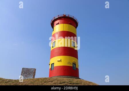 Il faro rosso e giallo Pilsum sul Frisone orientale Costa del Mare del Nord in Germania Foto Stock