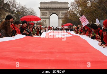 Gli attivisti formano una linea rossa gigante durante una manifestazione nei pressi dell'Arco di Trionfo sul viale Avenue de la Grande armee a Parigi, Francia, il 12 dicembre 2015, Come proposta di un accordo a 195 nazioni per contenere le emissioni dei gas che intrappolano il calore che minacciano di provocare il caos sul sistema climatico della Terra, sarà presentata alla conferenza delle Nazioni Unite sul cambiamento climatico COP21 a le Bourget, alla periferia di Parigi. Foto di Somer/ABACAPRESS.COM Foto Stock