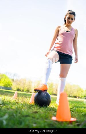 Giovane giocatore di calcio femminile che pratica sul campo. Foto Stock