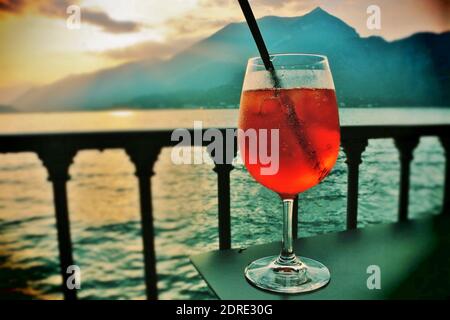 Godetevi un aperitivo rinfrescante al tramonto sul lago di Como. Foto Stock