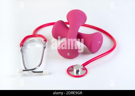 Pesi delle mani rosa e stetoscopio cuore sano Foto Stock