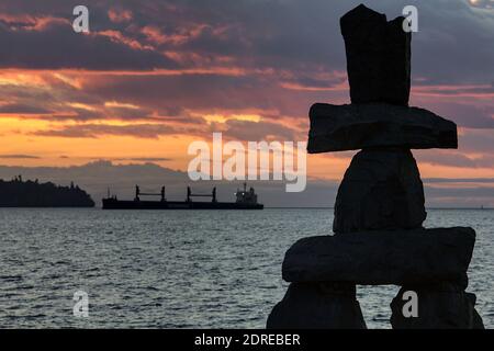 Silhouette di Inukshuk a English Bay con la nave da trasporto sullo sfondo, Vancouver, British Columbia, Canada Foto Stock