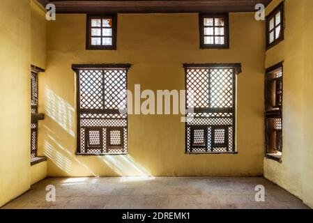 Facciata di due finestre in legno intarsio intarsio - Mashrabiya - in muro di pietra in edificio abbandonato Foto Stock