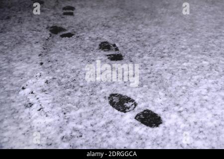 impronte nella neve di notte, stampe di scarpe da uomo, primo piano Foto Stock