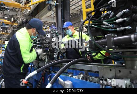 (201221) -- SHANGHAI, 21 dicembre 2020 (Xinhua) -- lavoratori finetune un motore su una linea di produzione di escavatori alla Volvo Construction Equipment (China) Co., Ltd. Nella Shanghai della Cina orientale, 17 dicembre 2020. Volvo Construction Equipment (Volvo CE), un produttore internazionale di attrezzature da costruzione, è entrato nel mercato cinese nel 2002, stabilendo la sua sede a Shanghai. Con l’epidemia di COVID-19 che rallenta lo slancio economico globale nel 2020, le imprese multinazionali vedono promettenti opportunità in Cina mentre il paese continua ad approfondire la propria apertura. Nel 2020 Volvo CE mov Foto Stock