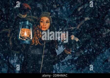 Giovane ragazza con lanterna in fiaba foresta invernale, copertina del libro Foto Stock