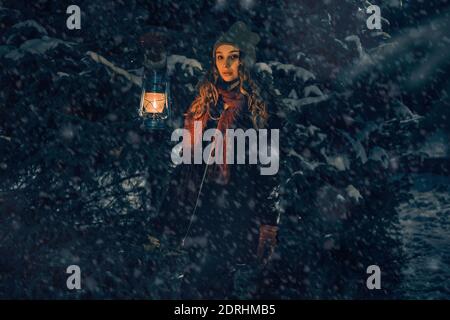 Giovane ragazza con lanterna in fiaba foresta invernale, copertina del libro Foto Stock