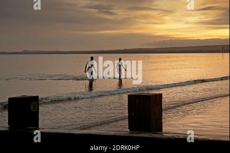 Portobello, Edimburgo, Scozia, Regno Unito. 21 dicembre 2020. Segnando il Solstizio d'inverno Anna e Andrew si tuffano al mattino presto all'alba nel Firth of Forth. Il giorno più breve dell'anno, segnando l'inizio dell'inverno. Credit: Arch White/Alamy Live News. Foto Stock