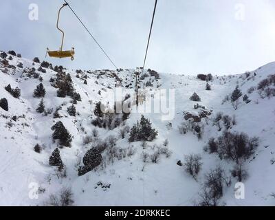 La gente sale sulla montagna su una funivia dentro Inverno nelle montagne innevate di Chimgan Foto Stock