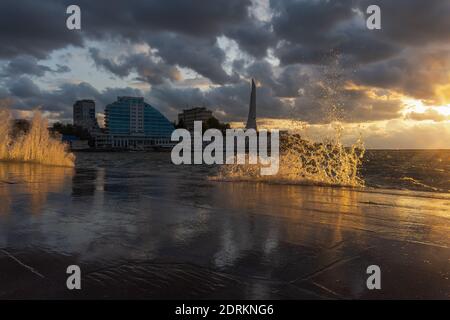 Tempesta a sevastopol al tramonto il 04 agosto 2019. Onde enormi si rompono sull'argine. Calda luce del tramonto. Paesaggio urbano d'estate. H Foto Stock